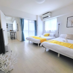 A hotel room with two beds, a kitchenette, a dining area, and a bathroom. - Floria Namba (Osaka)
