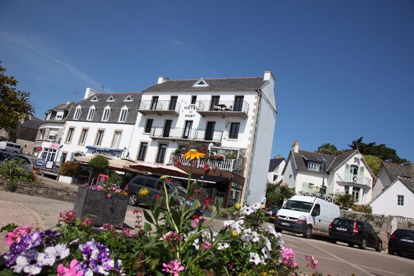 A multi-story hotel with balconies and a sign indicating it is a port hotel. - Hôtel du Port Locquirec (Locquirec)