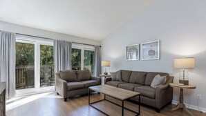 Een woonkamer met een bank, salontafel en twee lampen.