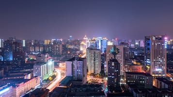 A cityscape at night with illuminated buildings and busy streets.