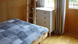 A wooden cabin room with a bunk bed, a desk, and a window with curtains. - Magnificent landscape, fjords and mountains and an unic sommer house. (Norangsfjorden)