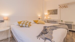 A modern bedroom with a large bed, bedside tables, a nightstand, a mirror, and a wall-mounted artwork. - The Apple House (Varenna)