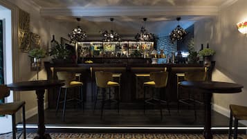 Eine Bar mit einer Theke, Barhocker und einem gemusterten Boden.