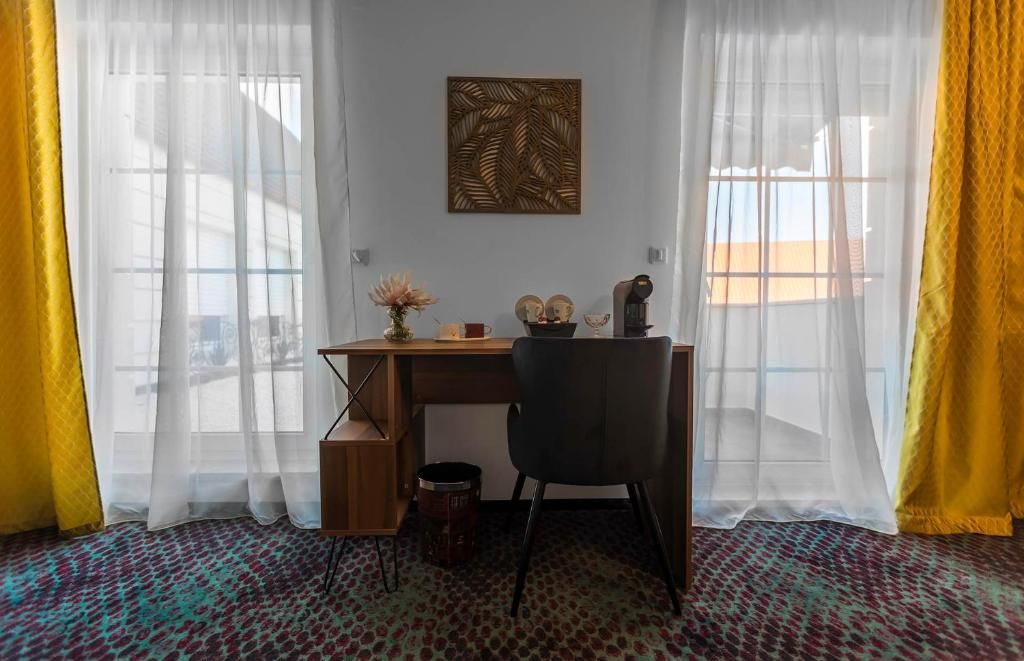 A room with a desk, chair, and a decorative wall piece.