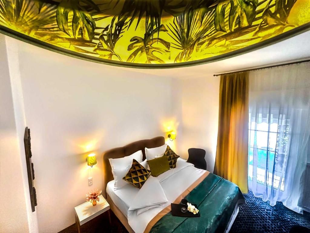 Ein Hotelzimmer mit einem Bett, Nachttischlampen, einem Nachttisch und einem Fenster mit Vorhängen.