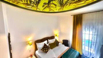 Ein Hotelzimmer mit einem Bett, Nachttischlampen, einem Nachttisch und einem Fenster mit Vorhängen.