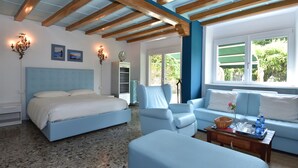 A bedroom with a bed, a blue armchair, a sofa, and a coffee table with a tray. - Bellagio Bed & Breakfast (Bellagio)