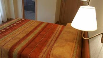 Un letto con una coperta a righe e una lampada da comodino.
