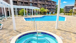 A swimming pool with a 3 FT depth marker, surrounded by a brick deck and white lounge chairs. - Experience Tilghman Beach and Racquet Club Unit 309! 3 Bedroom Ocean View Condo. Pools, Tennis, Close to Main Street! (North Myrtle Beach)