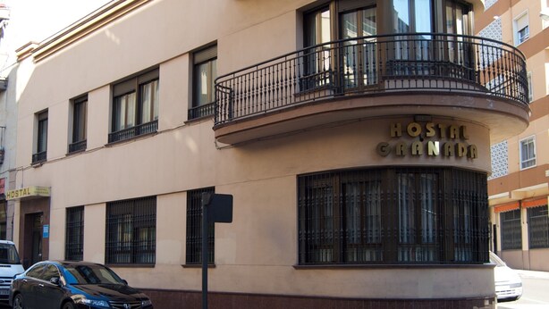 Un edificio con facciata curva, un'insegna che riporta 