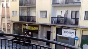 Un balcone con ringhiera in metallo che si affaccia su una strada.