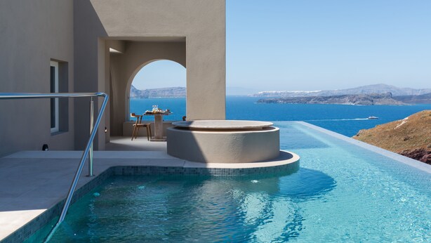 A modern infinity pool with a clear view of the sea and distant mountains. - Arota Exclusive Villas (Santorini)