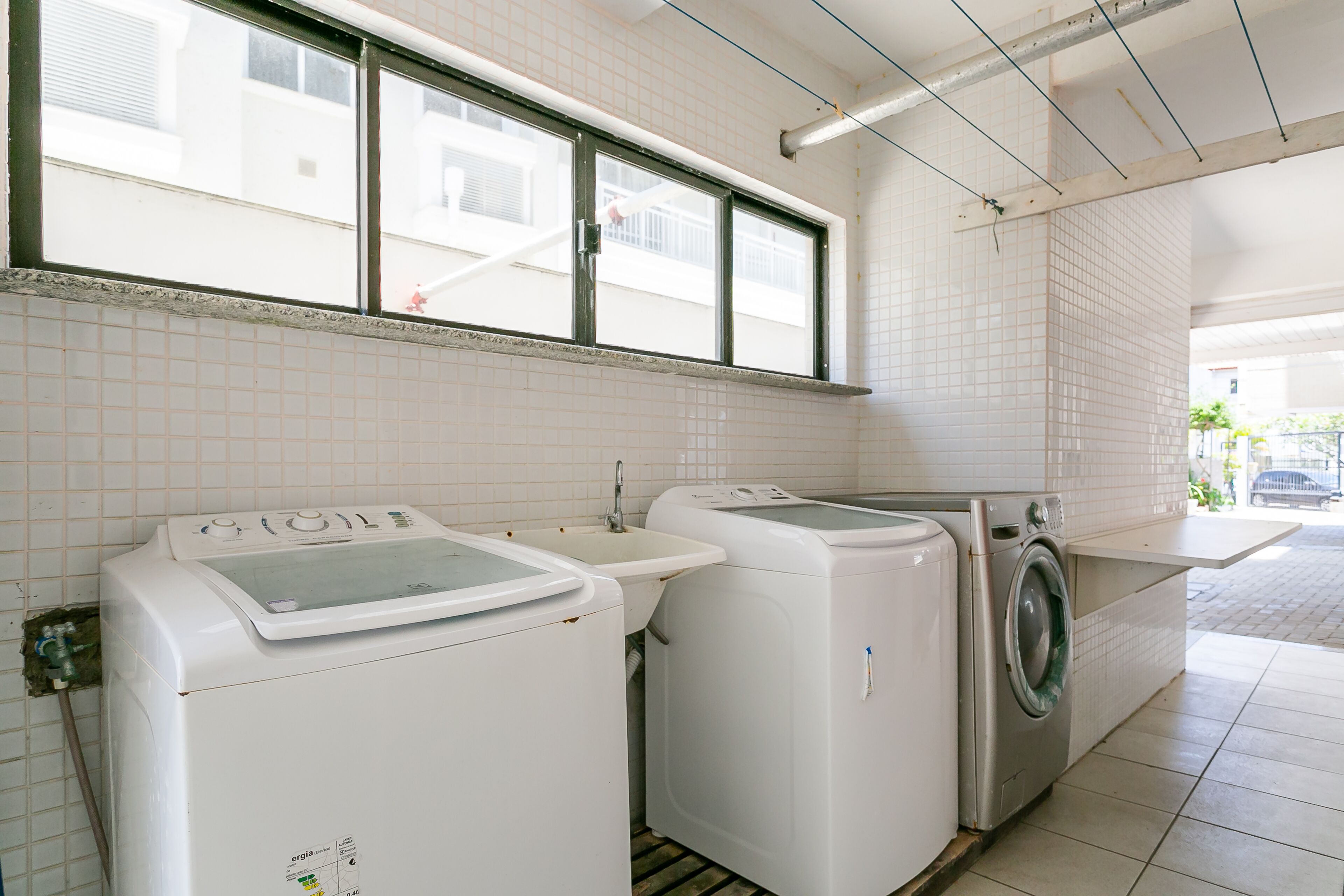A laundry area with two washing machines and a sink.