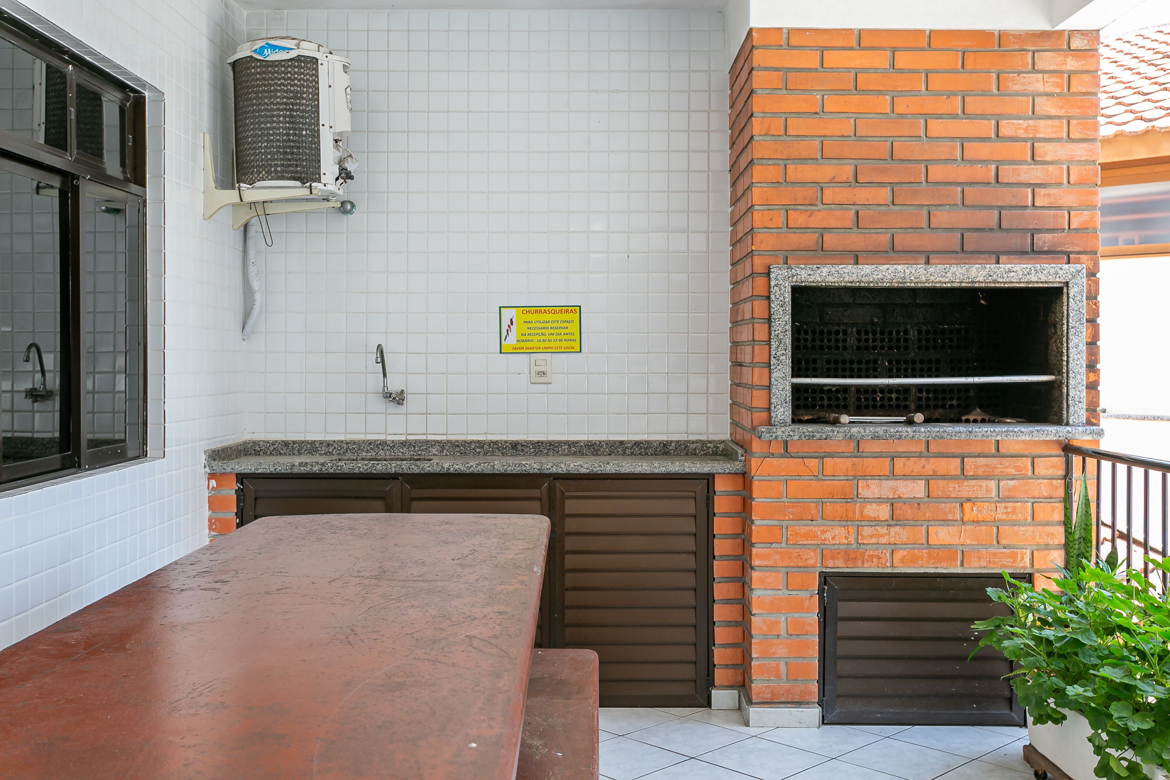 A kitchen with a tiled backsplash, a brick oven, and a countertop.