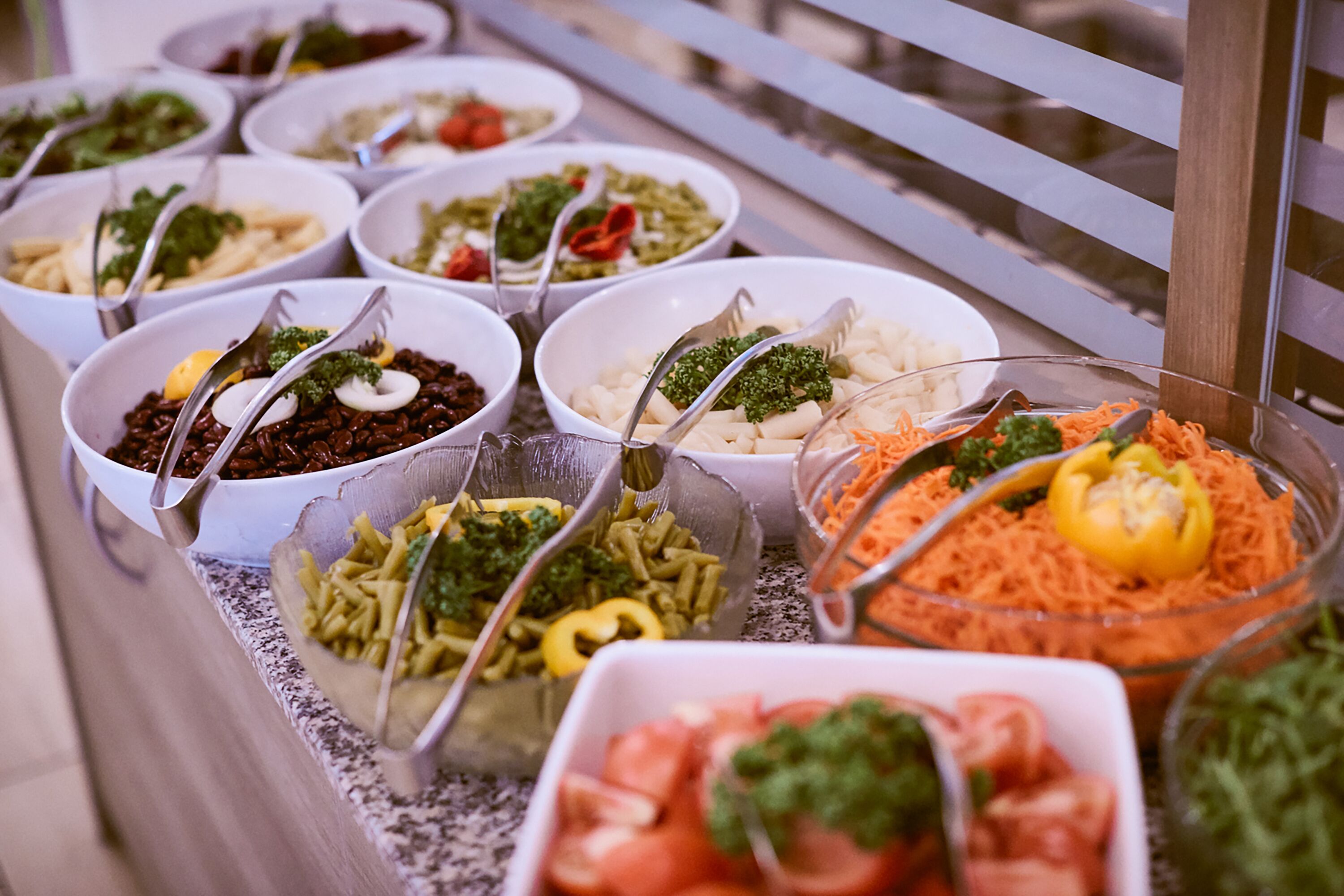 Buffet amb diferents plats, incloent pasta, amanides i verdures.