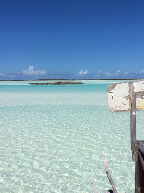 A clear turquoise sea with a wooden structure in the foreground.