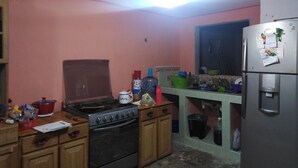 Eine Küche mit Holzausstattung, einem Herd und einem Kühlschrank.