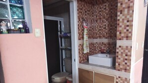 Ein kleines Badezimmer mit Toilette, Waschbecken und Holzschränken.