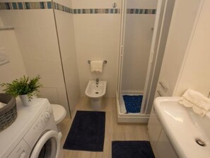A compact bathroom with a washing machine, a bidet, a shower, and a bathtub. - Renovated sea-facing studio with terrace in Menton (Menton)