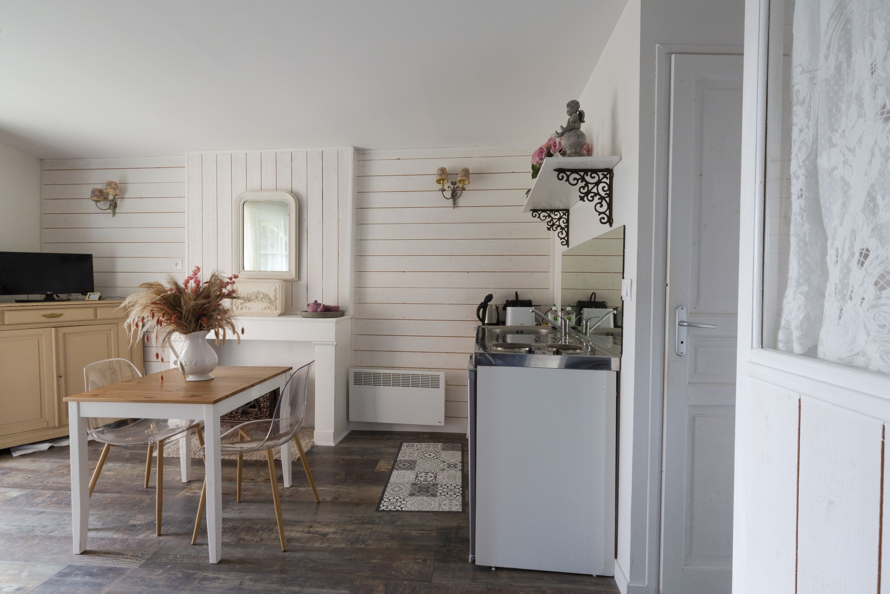 Una cocina compacta con comedor, un refrigerador blanco y un lavamanos pequeño.