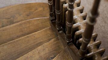 A wooden staircase with a glass ball on the top of the handrail.