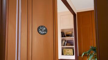A wooden door with a sign that reads 'Le Café des Voyageurs.'