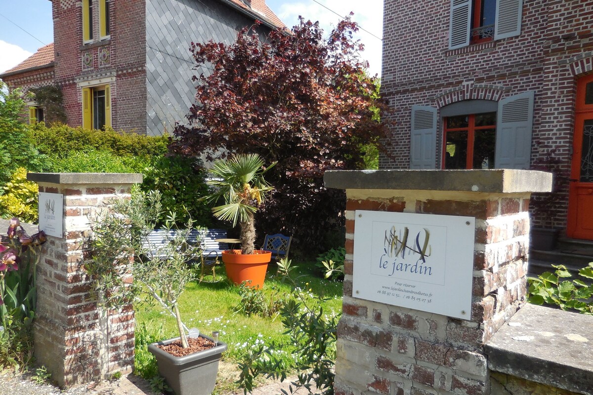 Un espace jardin aménagé avec des plantes en pot et une pancarte indiquant « le jardin ».