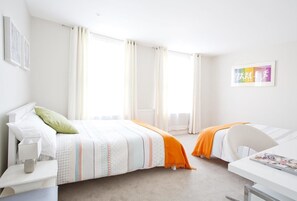 A bedroom with a bed, two bedside tables, a desk, and a chair. - Central Apartment with Wifi (London)