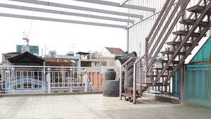 Un edificio de estilo industrial con suelo de baldosas, escaleras de metal y una entrada protegida por una reja.