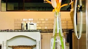 Une cuisine moderne avec un vase en verre transparent contenant des fleurs, posé sur le plan de travail.