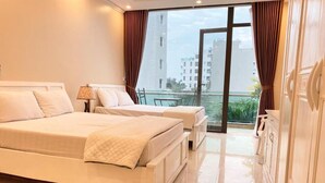 A hotel room with a large bed, a smaller bed, a balcony with a view of the city, and a wardrobe.