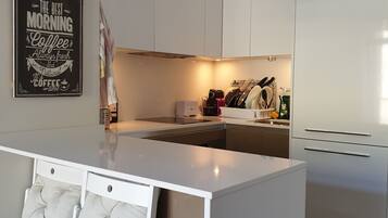 Microondas, lavavajillas, cafetera o tetera y utensilios de cocina