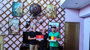 A room with a wooden floor, a television, and a door. There are paintings on the wall and a decorative item hanging above the television. - Tagaytay Karakol Hotel (Karakol)