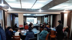 A conference room with round tables, attendees seated, and a presentation screen at the front. - Tagaytay Karakol Hotel (Karakol)