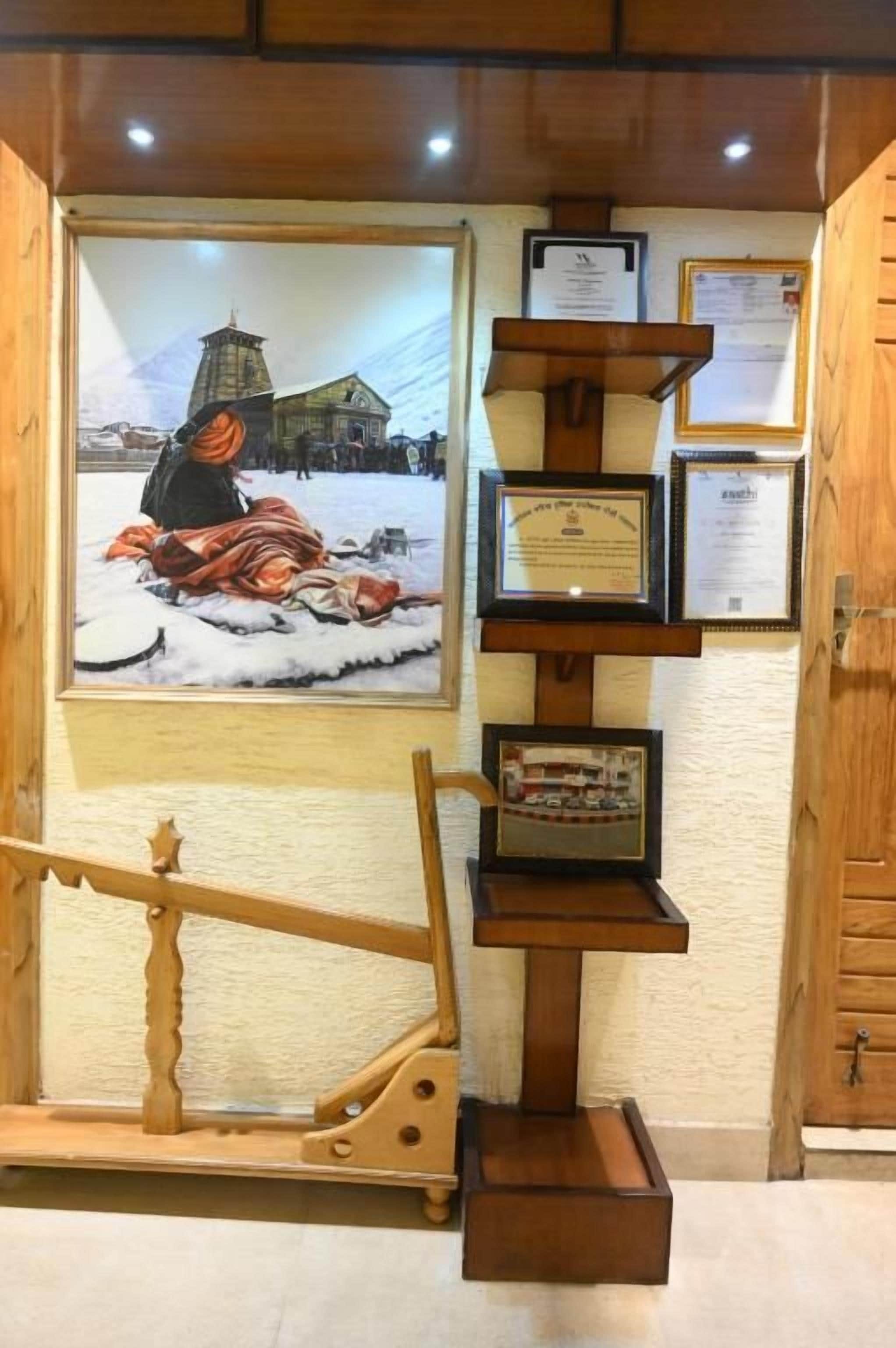 A wooden display with a framed picture of a snowy scene, a wooden structure resembling a sled, and several framed certificates or awards.