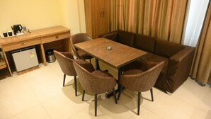 A compact living space with a kitchenette, a dining table, and a sofa. - Hotel Grand Kailash (Lansdowne)