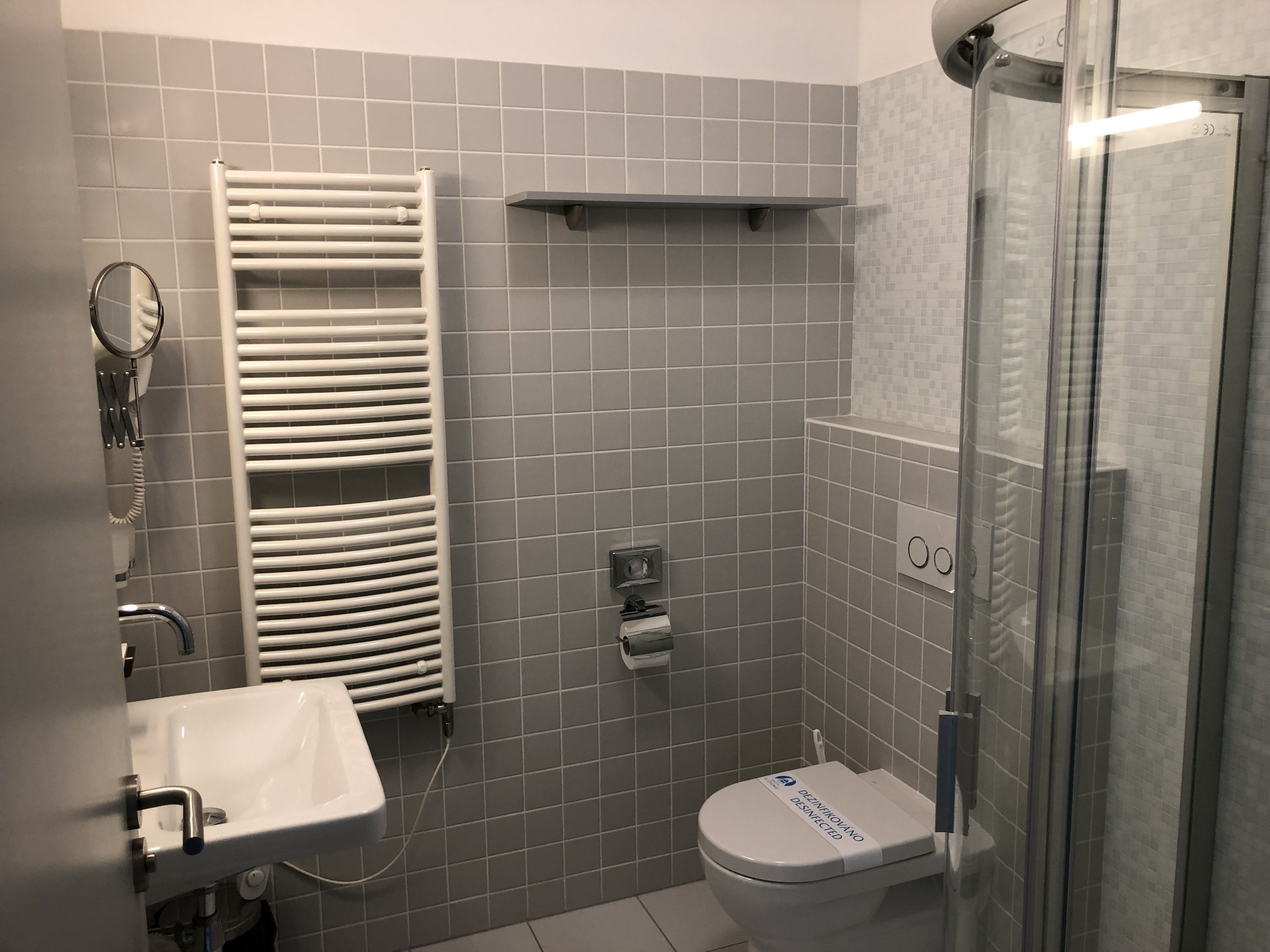 Ein Badezimmer mit Toilette, Waschbecken und einer Duschkabine aus Glas.