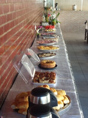 A buffet table with various food items and a coffee station.