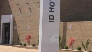 Señal del Hotel ID con un edificio moderno al fondo.