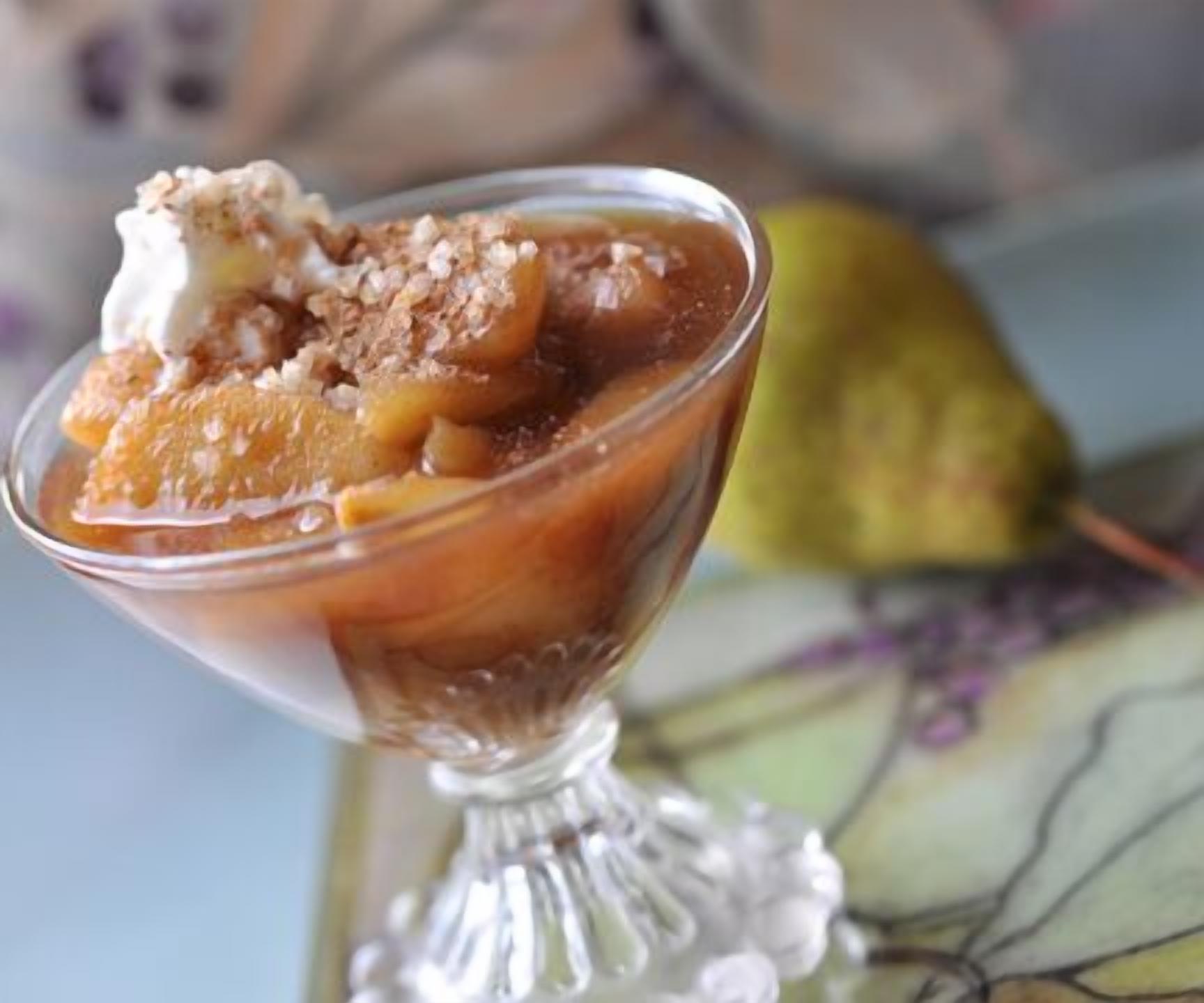 Postre en cuenco de cristal con cobertura caramelizada y una bola de helado.