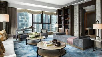 A modern living room with a sofa, armchairs, a coffee table, and a bookshelf.