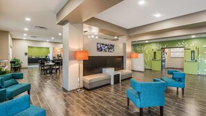 Un vestíbulo amplio con una recepción, zona de estar y una kitchenette al fondo.