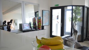 A reception area with a desk, computer, and a fruit bowl. There is a map on the wall and a giraffe statue. - Pier39Portrush (Portrush)