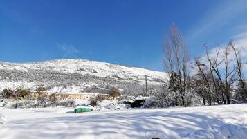 Schneebedeckte Landschaft mit einem Gebäude im Hintergrund.