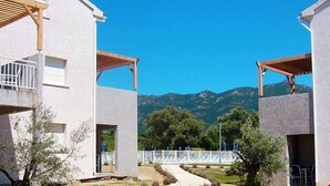 Un edificio moderno con balcón y vistas a las montañas.