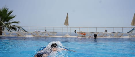 Een seizoensgebonden buitenzwembad, parasols voor strand/zwembad