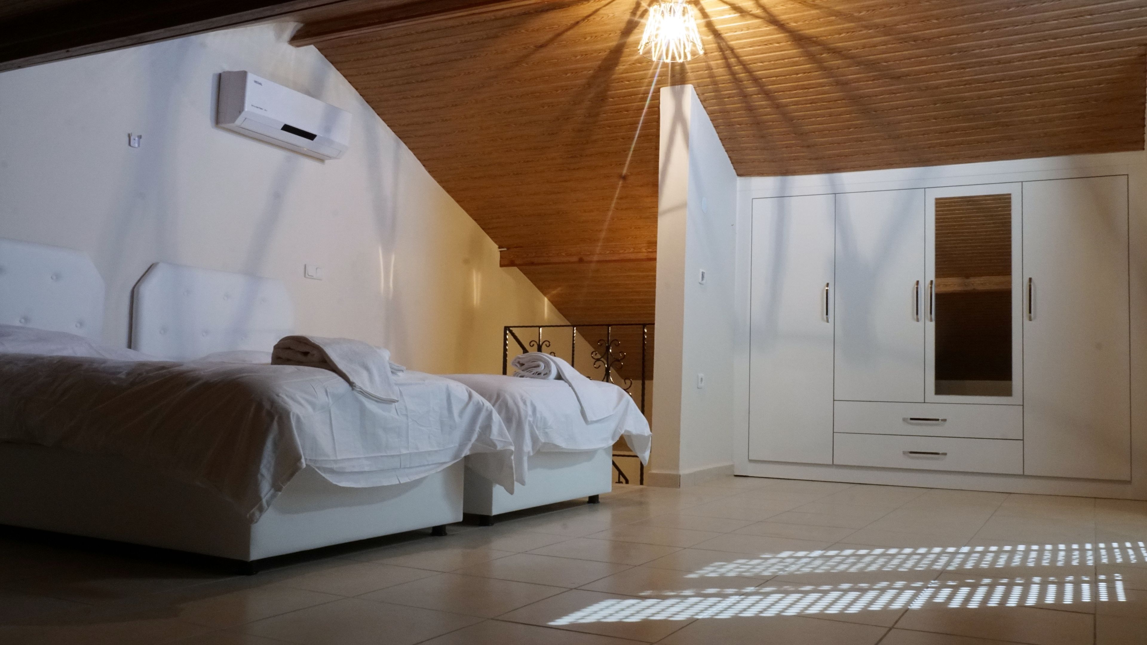 A bedroom with a bed, a wardrobe, and a ceiling light.