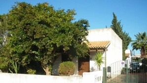 A building with a white facade, a tiled roof, and a gated entrance. - VILLETTA MAGNOLIE in residence 400 mt from the sea, wi-fi free parking space. (San Vito Lo Capo)