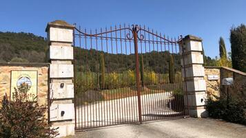 A gated entrance with a stone wall and a metal gate.