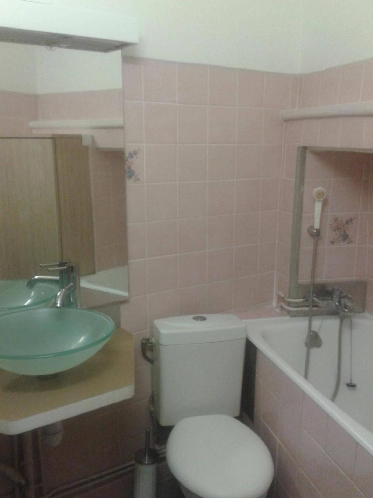 Une salle de bain avec un lavabo en verre, des toilettes et une baignoire.